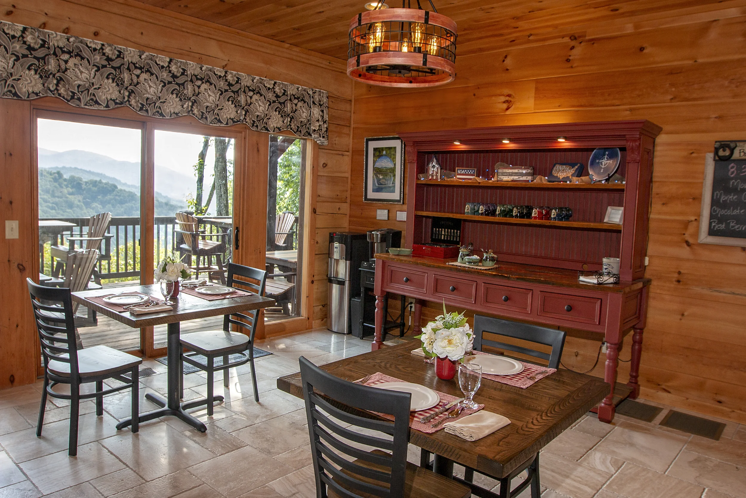 Dining room features five individual tables for couples, fireplace, buffet counter, guest refrigerator, microwave, beverage center and spectacular views of the front gardens and mountain views out the